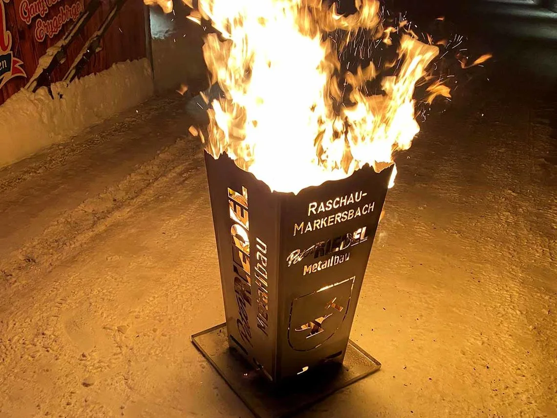 Brennender Feuerkorb mit dem Schriftzug Raschau-Markersbach vor der Werkstatt
